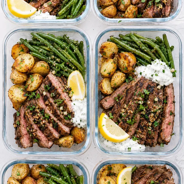 Garlic butter steak and potato bowls portioned into meal prep containers.